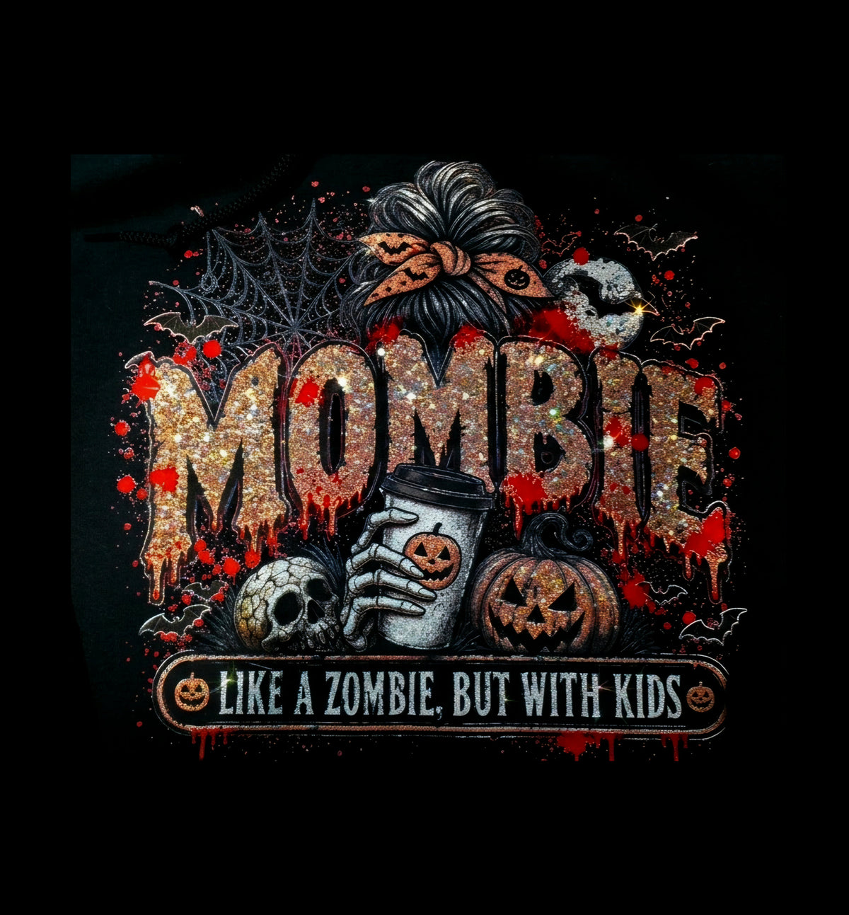 A close-up of a black graphic print featuring the word 'MOMBIE' in glittery orange letters with red dripping effects, surrounded by Halloween motifs including a skull, jack-o'-lanterns, a spiderweb, a moon, and a hand holding a coffee cup. Below the main graphic is a banner reading 'LIKE A ZOMBIE, BUT WITH KIDS'.