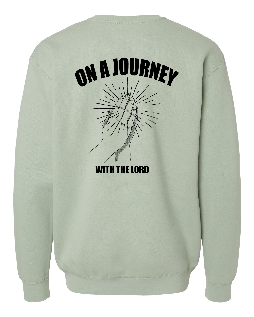 A sage green crewneck sweatshirt shown from the back, featuring a black graphic of praying hands with radiating lines and the text 'ON A JOURNEY WITH THE LORD'.