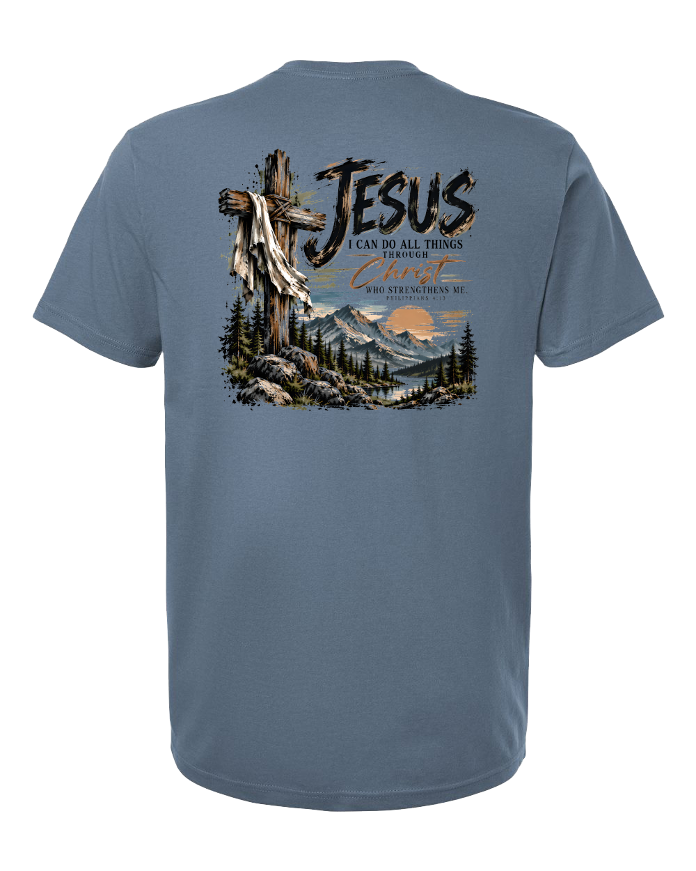 A slate blue short-sleeve t-shirt shown from the back, featuring a large graphic print with a wooden cross draped in a white cloth, a mountain landscape, and the text 'JESUS' and 'I CAN DO ALL THINGS THROUGH Christ who strengthens me'.